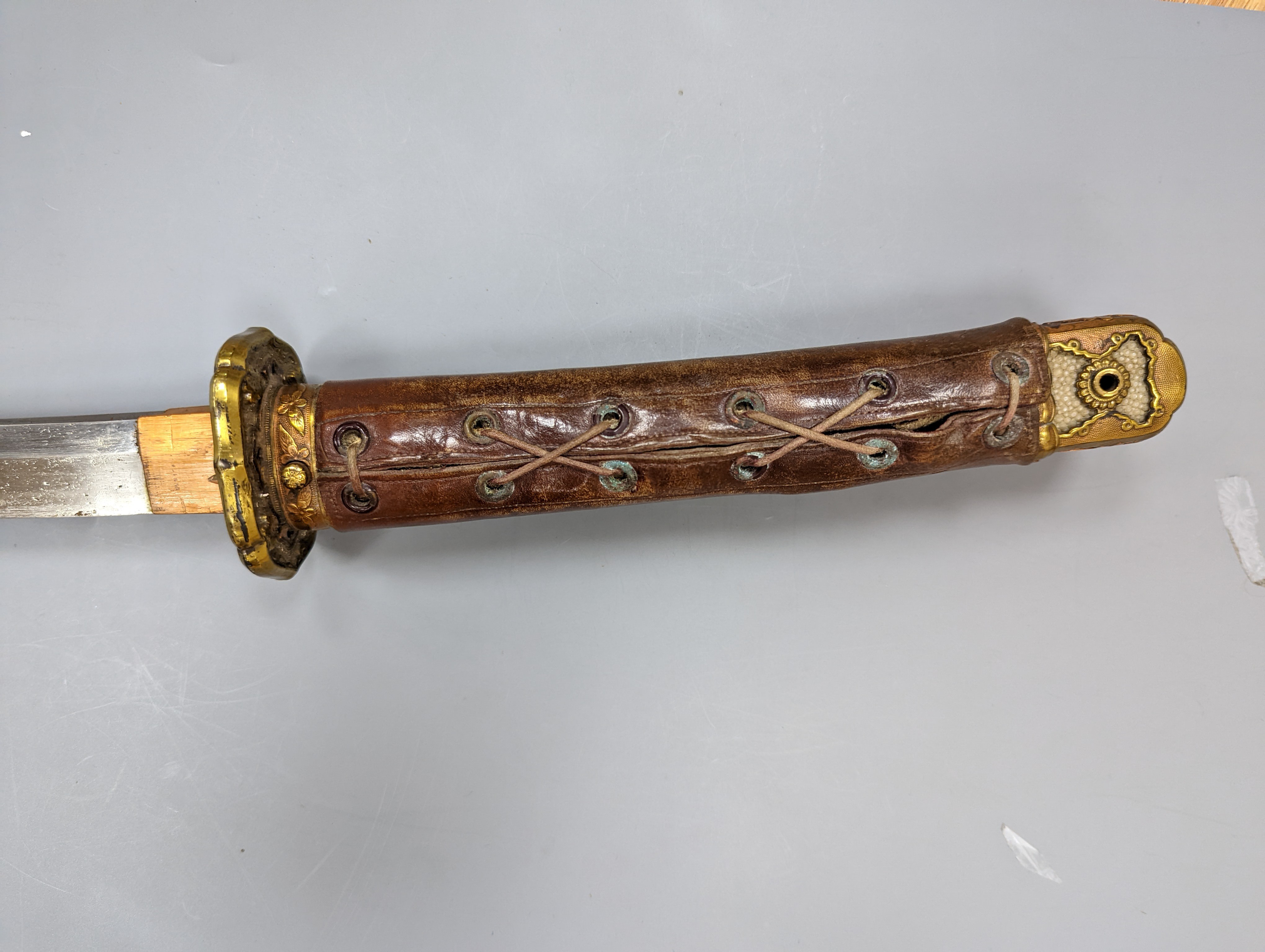 A Japanese Katana with leather covered sheath, plaque reading ‘Presented to Capt. S. Mear Telecoms B.M.A’ 93 cms long.